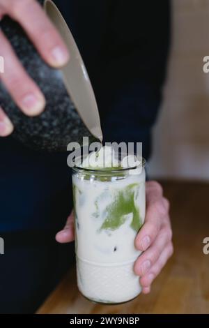 pouring green tea into milk for matcha latte Stock Photo