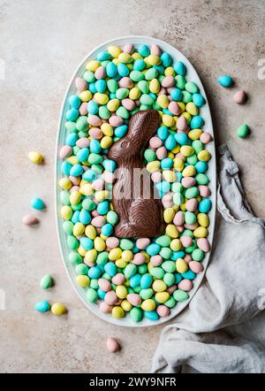 Overhead of chocolate bunny in tray of mini chocolate Easter eggs. Stock Photo