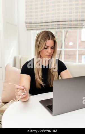 Concentrated woman working on laptop at home Stock Photo