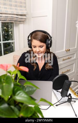 A lively podcaster interacts during a recording session in her home Stock Photo