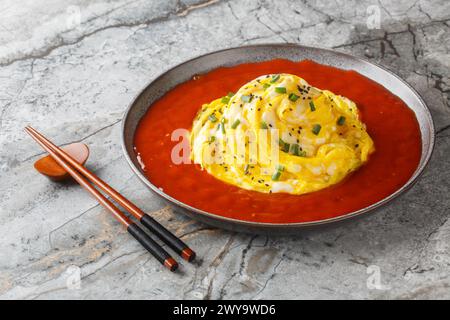 Korean Tornado Egg Omelette with Fried Rice and Sriracha Ketchup closeup on the plate on the table. Horizontal Stock Photo