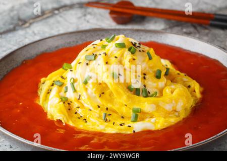 Swirl omelette tornado with fried rice and hot pepper sauce close-up in a plate on the table. Horizontal Stock Photo