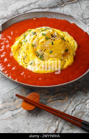 Tornado Omelette Omurice with Sriracha Ketchup closeup on the plate on the table. Vertical Stock Photo