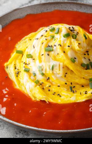 Tornado omelet a Korean dish called a tornado omurice, where a whirlwind of scrambled egg is placed over a mound of rice, and surroun sauce closeup on Stock Photo