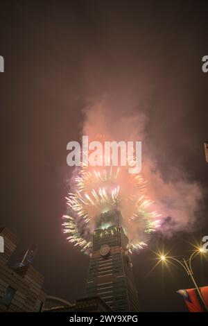 The sky is lit up with a spectacular display of fireworks from Taipei 101 tower Stock Photo