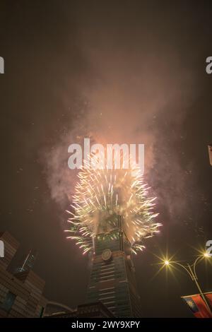 The sky is lit up with a spectacular display of fireworks from Taipei 101 tower Stock Photo