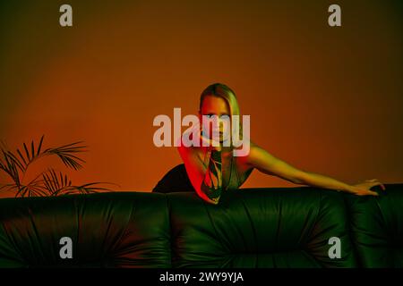 A woman sitting comfortably on a couch in a room Stock Photo