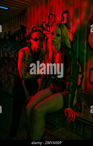 A man and a woman sitting closely next to each other at a lively rave party Stock Photo