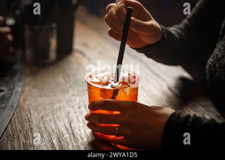 Aperol spritz cocktail in hands. Bar costumer concept Stock Photo