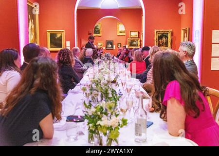 Wedding guests sat a dinner table during a speech at a wedding at Dulwich Picture Gallery in London, UK Stock Photo