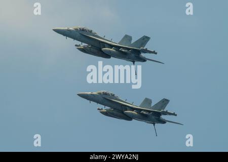 SOUTH CHINA SEA (March 27, 2024) A pair of EA-18G Growlers, assigned to the “Rooks” of Electronic Attack Squadron (VAQ) 137, fly above the Nimitz-clas Stock Photo