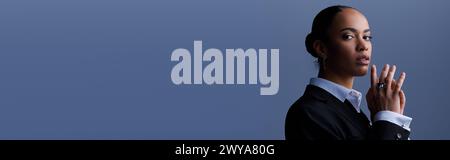 A young African American businesswoman in a stylish suit holding her hands together, banner Stock Photo