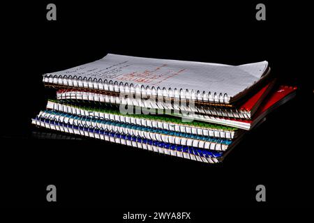 Six (6) spiral bound notebooks stacked on top of each other, notes showing Stock Photo