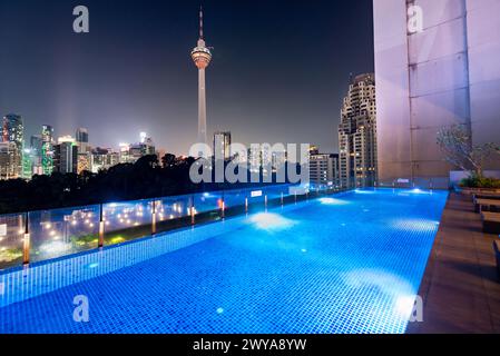 Kuala Lumpur,Malaysia-April 20 2023: The hotel swimming pool and bar area,offering views across the modern city skyline and KL Tower. Stock Photo