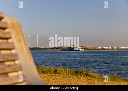 Beautiful windmills in the port of Rotterdam. Beautiful sunset on the sea coast. The Blue North Sea and Water surface. The lighthouse and shore are li Stock Photo