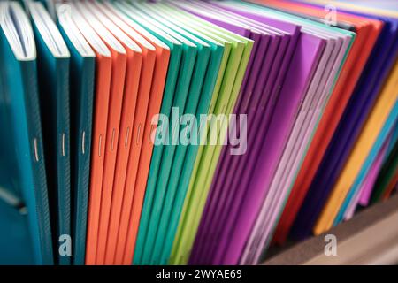Notebooks of different bright colors are on the shelf. High quality photo Stock Photo