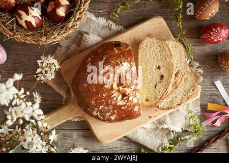Slices of Czech sweet Easter cake called mazanec, with eggs dyed with onion peels and decorated  with wax, top view Stock Photo