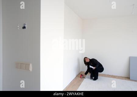 Interior decorator taking measures in empty room. Stock Photo