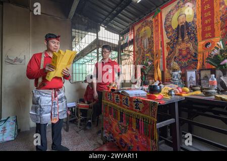 A traditional shaman performing a ritual with offerings to the ancestors on an altar in Donggyue Hall temple Stock Photo