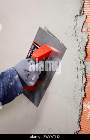 Rendering a brick wall using trowel, new homes under construction, construction site. Stock Photo