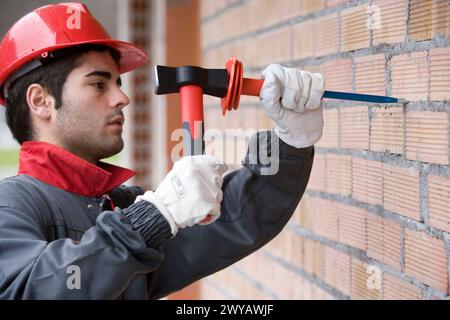 Worker with mallet and chisel, building construction. Stock Photo