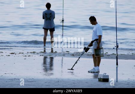 Fisherman and man using a metal detector at beach. Hendaye. France. Stock Photo