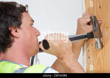 Carpenter with hammer with carbon fiber handle. Construction of residential building. Donostia. San Sebastian. Gipuzkoa. Basque Country. Spain. Stock Photo