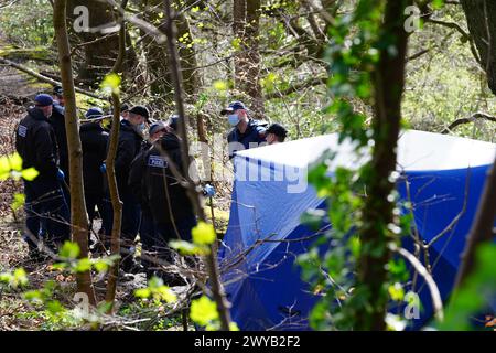 Police officers by a forensic tent at Kersal Dale, near Salford, Greater Manchester, where a major investigation has been launched after human remains were found on Thursday evening. Greater Manchester Police (GMP) said officers were called by a member of the public who found an 'unknown item wrapped in plastic'. Picture date: Friday April 5, 2024. Stock Photo
