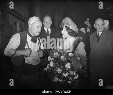 A ROYAL VISIT TO THORP ARCH ROYAL ORDNANCE FACTORY, WETHERBY, YORKSHIRE, ENGLAND, UK, 1941 - HM Queen Elizabeth talks to a forge man, Mr H Greenwood, during a visit to ROF Thorp Arch. HM The Queen is carrying a large bouquet of flowers. , Elizabeth, Queen Stock Photo