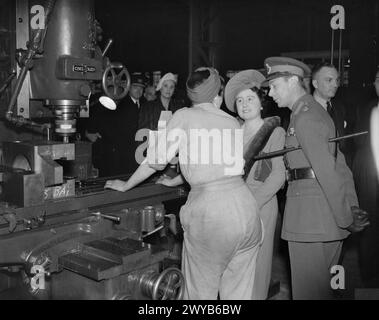 A ROYAL VISIT TO THORP ARCH ROYAL ORDNANCE FACTORY, WETHERBY, YORKSHIRE, ENGLAND, UK, 1941 - HM King George VI and HM Queen Elizabeth talk to a munitions worker as she stands at her machine, during a visit to ROF Thorp Arch. , George VI, King, Elizabeth, Queen Stock Photo