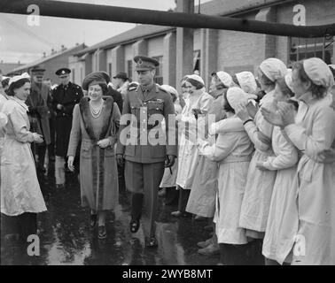 A ROYAL VISIT TO THORP ARCH ROYAL ORDNANCE FACTORY, WETHERBY, YORKSHIRE, ENGLAND, UK, 1941 - Munitions workers cheer and clap as HM King George VI and HM Queen Elizabeth leave ROF Thorp Arch following a visit to watch the women at work in this filling factory. , George VI, King, Elizabeth, Queen Stock Photo