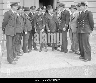 NEW ZEALAND HIGH COMMISSIONER INSPECTS NAVAL PERSONNEL. 2 AND 3 JUNE 1943, HMS BEEHIVE AND HMS MIDGE. THE HIGH COMMISSIONER FOR NEW ZEALAND, MR W J JORDAN, TOGETHER WITH THE MINISTER FOR DEFENCE, THE HON FREDERICK JONES, VISITED BASES OF LIGHT COASTAL FORCES ON THE EAST COAST AND INSPECTED NEW ZEALAND PERSONNEL. - The High Commissioner (centre) and the Minister for Defence (left) talking to New Zealand Officers at HMS BEEHIVE, Felixstowe. Among the officers are Lieut Commander S C Bradley (Wellington), Sub Lieut R A Mitford-Burgess (Te Araroa), Sub Lieut G J Macdonald, DSC (Wellington), Sub Li Stock Photo