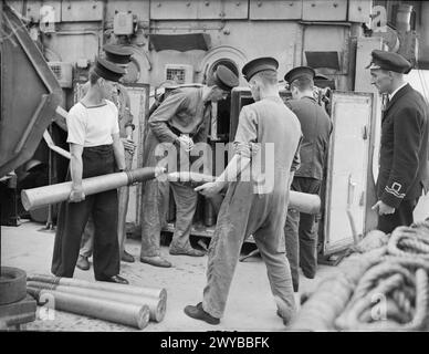 LIFE ON BOARD HM CORVETTE WIDGEON, AUGUST 1943, IN THE NORTH SEA AND AT HARWICH, MEN OF THE CORVETTE WIDGEON GO ABOUT THE EVERYDAY JOBS OF THEIR WARTIME ROUTINE. - The First Lieutenant watching ammunition being taken in and stored in the ready use lockers. , Royal Navy, HMS Wigtown Bay, Frigate, (1945) Stock Photo