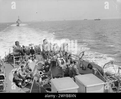 LIBERATION OF EUROPE: WITH AN INVASION COAST CONVOY ESCORT. 11 TO 13 JUNE ON BOARD THE FRIGATE HMS HOLMES GUARDING THE ALLIED SUPPLY LINES TO AND FROM THE NORMANDY BEACHHEAD. - HMS SOUTHDOWN, Hunt class destroyer following astern when passing an East Coast convoy. , Stock Photo