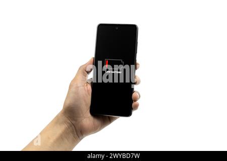 Cellular Problems and Energy Concepts. Man hand holding smart phone with low battery icon on screen isolated on white background. All screen graphics Stock Photo