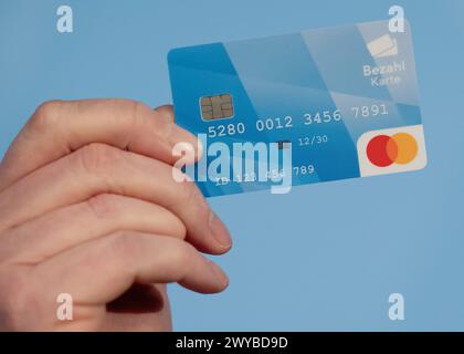 Munich, Germany. 20th Mar, 2024. A man holds a payment card during a press conference. After weeks of arguing, the parliamentary groups of the traffic light coalition have agreed on a draft for a nationwide legal basis for the introduction of a payment card for refugees. This was announced by the SPD, Greens and FDP on Friday. The draft states that the payment card is a suitable means of preventing money payments to people smugglers, for example. Credit: Sven Hoppe/dpa/Alamy Live News Stock Photo