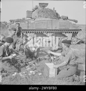 THE BRITISH ARMY IN THE NORMANDY CAMPAIGN 1944 - The crew of a Sherman tank of 1st Northamptonshire Yeomanry receive rations before the start of Operation 'Totalise', 7 August 1944. , Stock Photo