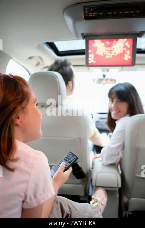 Family travelling, girl watching DVD in car. Stock Photo