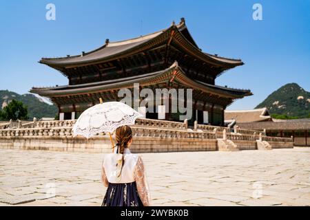 Seoul, South Korea. Gyeongbokgung Palace. Woman in hanbok, traditional Korean dress, costume and clothes. Travel tour and tourism at landmark. Stock Photo