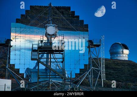 The Magic Telescopes, Roque de los Muchachos Observatory, La Palma, Canary Islands, Spain. The cosmos and its evolution are studied using all radiation, in particular electromagnetic waves. The observable spectrum extends from radio waves to infrared, visible, ultraviolet, X-ray, gamma-rays and finally very high energy gamma rays (starting at energies of 10 GeV). Observations at visible wavelengths (.5 to 1 micrometer) have a history of centuries, gamma astronomy by satellites (keV to few GeV) and ground-based telescopes (above 300 GeV) are end-of-20th century newcomers. The MAGIC telescope ca Stock Photo