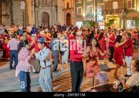 Oaxaca, Mexico - The weekly Wednesday dance in the zocalo, or central square. This night the dance was on Valentine's Day, with many dancers wearing r Stock Photo