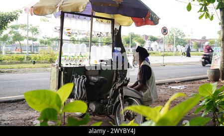 An old man who was sitting looking at the street and waiting for someone to buy the ornamental fish he was selling Stock Photo