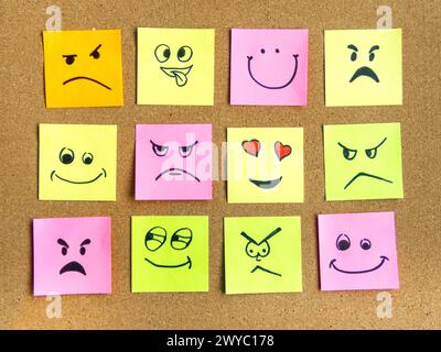 cork board with colorful post its representing various emoticons with various emotions communication concept Stock Photo