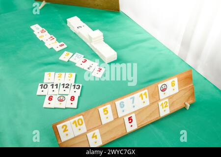 Plastic tiles from the game rummikub, rummicub or  okey in Turkey arranged on a wooden rack Stock Photo