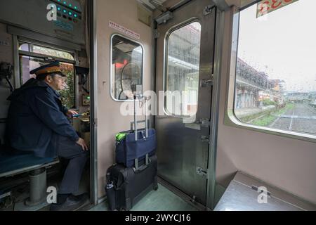 Inside view of a train driver’s cabin with a focused driver at the station, showcasing the behind-the-scenes of railway operations Stock Photo