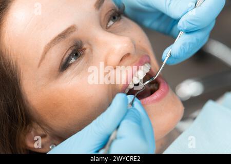 In the dental office, the doctor confidently works with modern equipment and tools, providing the patient with effective and painless dental care Stock Photo