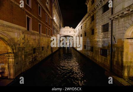 Architecture: the iconic historic building: the stone Bridge of Sighs over the Rio di Palazzo canal illuminated at night in San Marco, Venice, Italy Stock Photo