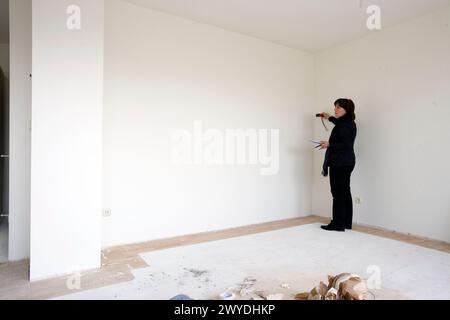 Interior decorator taking measures in empty room. Stock Photo