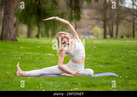 Woman doing side stretch in yoga pose outdoors. Stock Photo