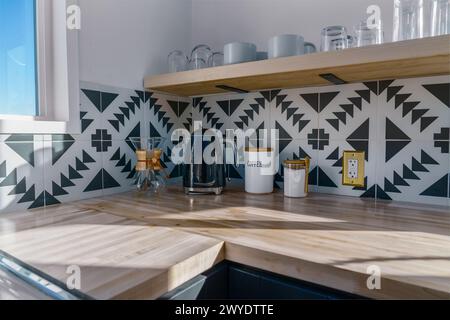 Coffee area in a coffee pot glass brewer containers and cups glasses in a modern kitchen with black and white tile Stock Photo
